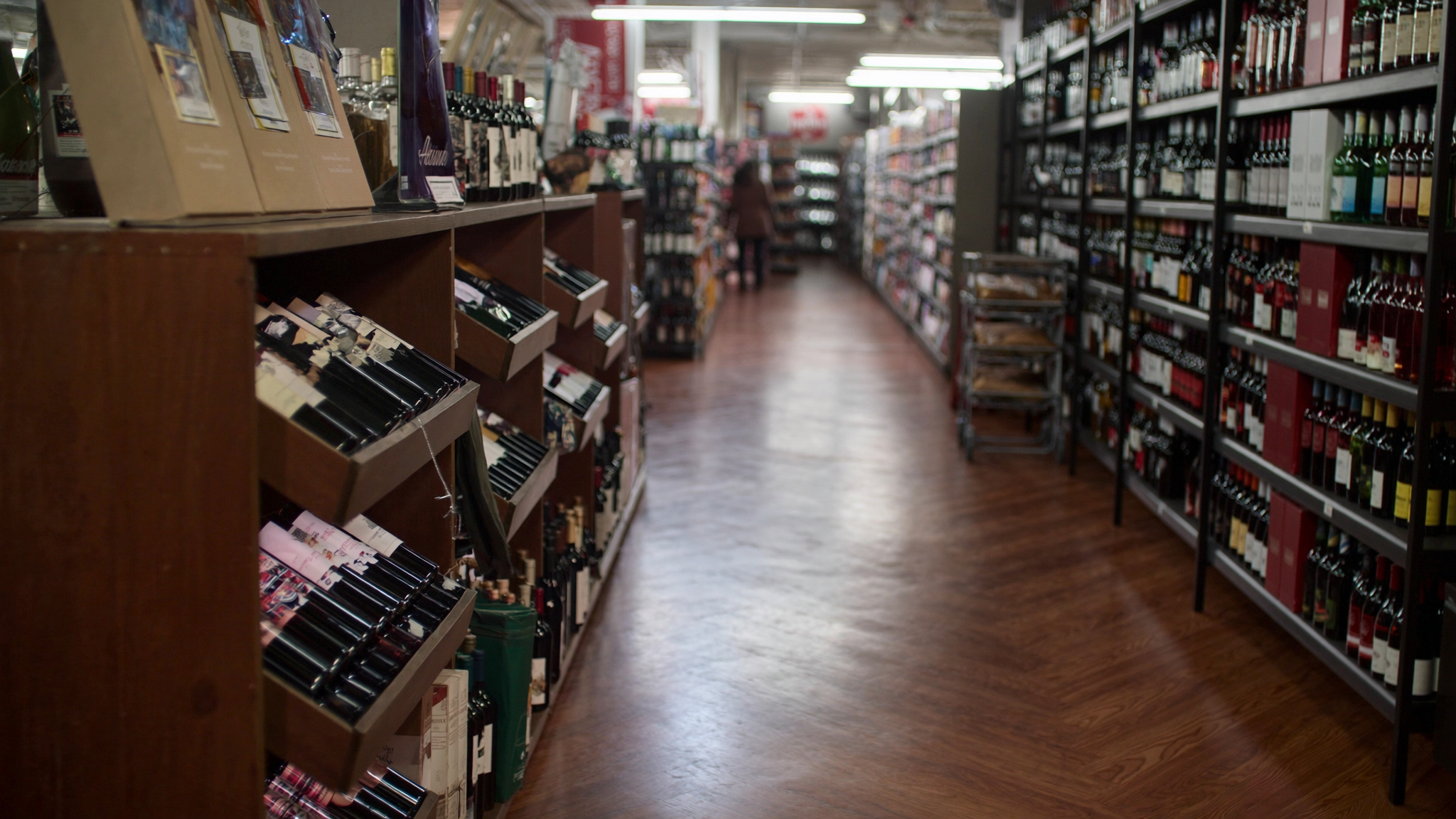 Modern liquor store interior with organized aisles of wine and spirits on dark wooden shelving — the retail environment that field audits and secret shopper programs assess