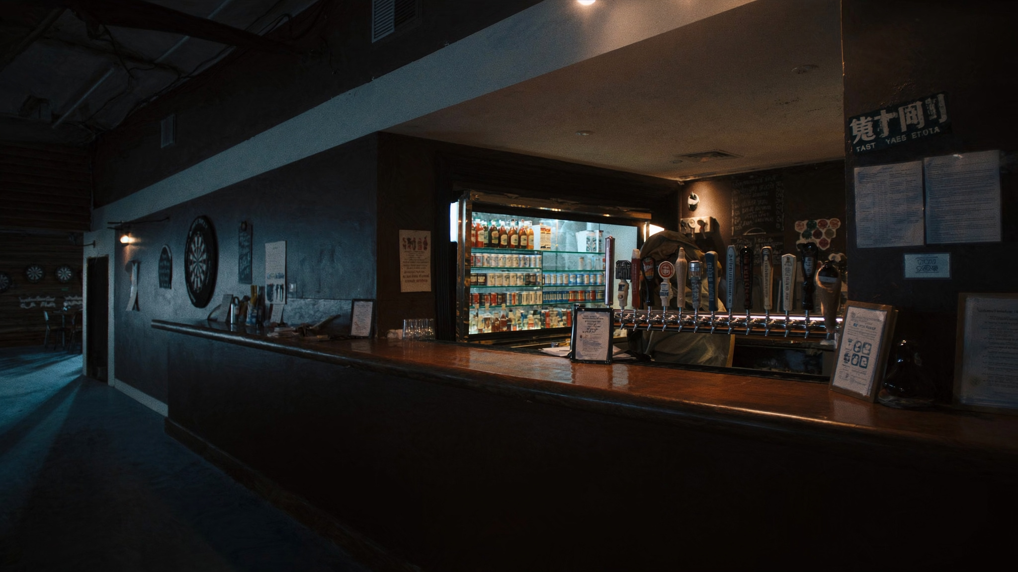 Bar interior with row of illuminated branded beer tap handles and cooler displays — the on-premise point-of-sale marketing environment
