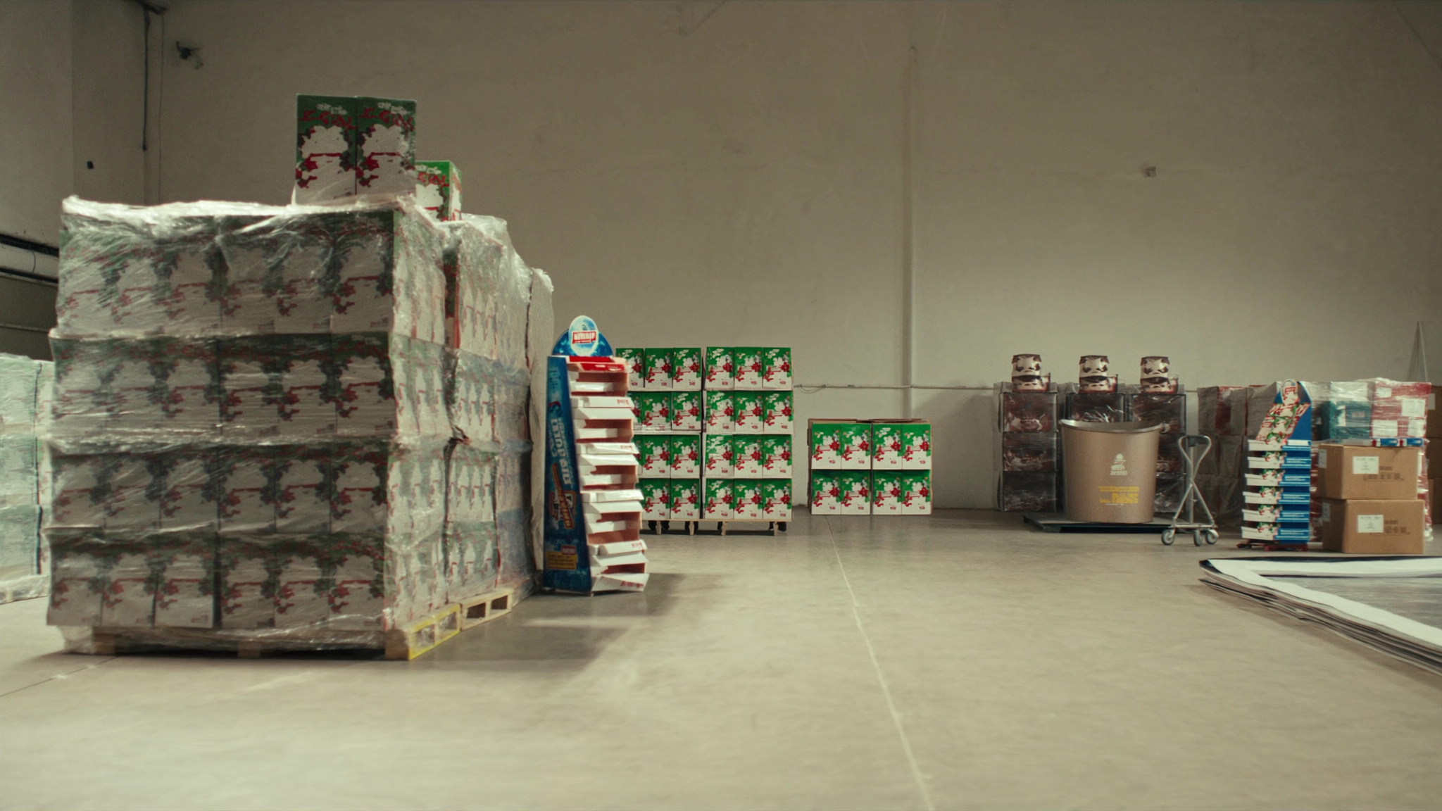 Beverage distributor warehouse staging area with stacks of branded POS materials and display boxes — marketing collateral ready for field deployment